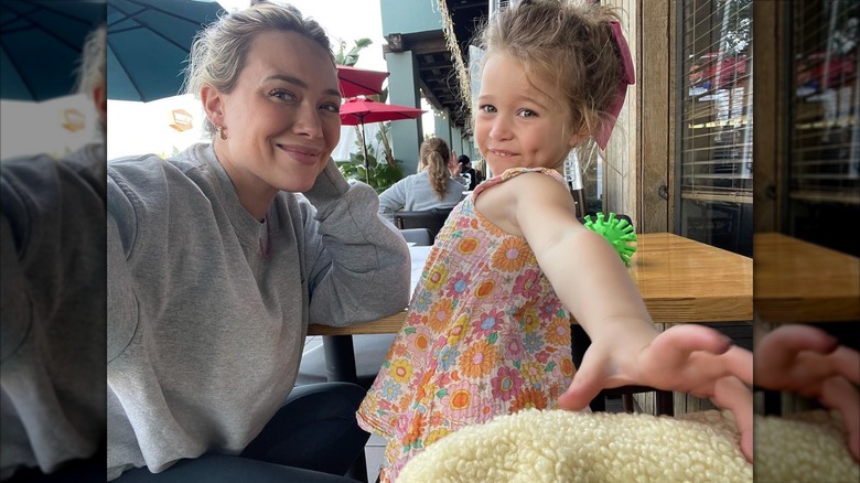 Hilary Duff porte ses cheveux en chignon en désordre et un sweat-shirt gris alors qu'elle est assise avec Banks dans un restaurant de sushi.