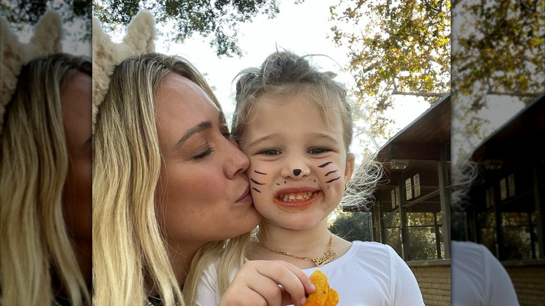 Hilary Duff porte des oreilles de chat avec ses cheveux blonds détachés tout en embrassant sa fille Banks sur la joue pour célébrer Halloween.