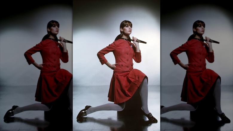 Jean Shrimpton pose portant une jupe de costume rouge coordonnée