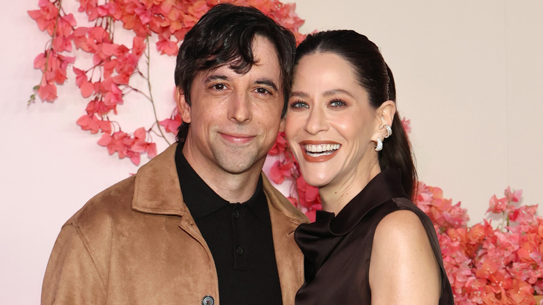 Jackie Tohn et son petit ami Joe Gillette sourient alors qu'ils posent pour les caméras sur le tapis rouge.