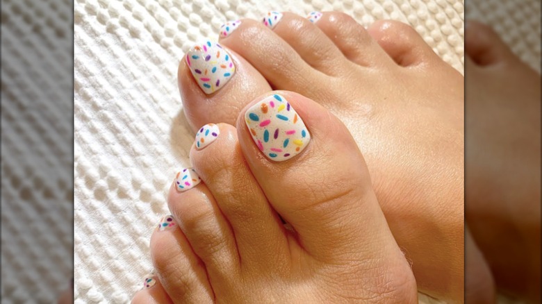 Une pédicure au design multicolore ressemblant à des confettis
