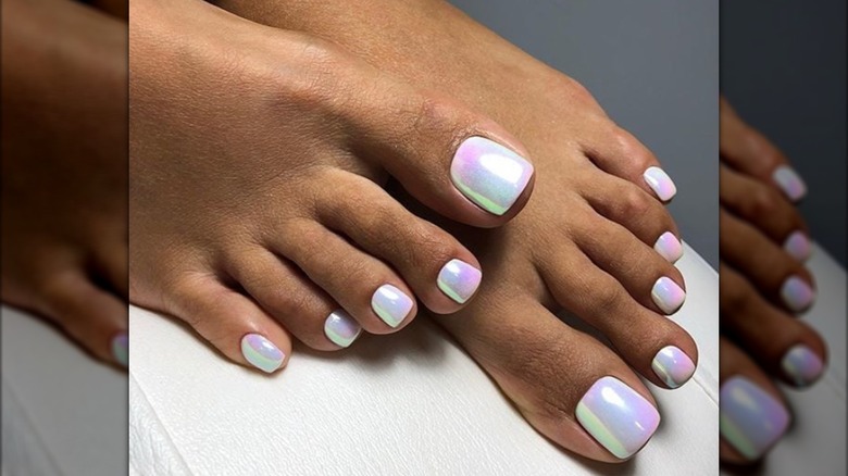 Une pédicure avec du vernis nacré irisé