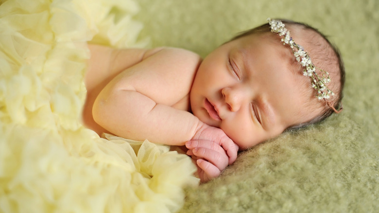 Bébé dort avec une couronne de fleurs
