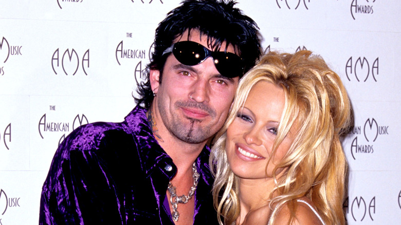Tommy Lee et Pamela Anderson se font des câlins lors d'un événement.