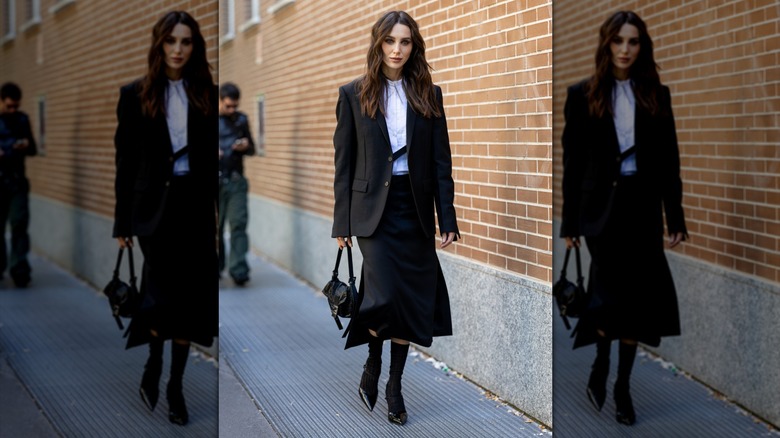 Une femme avec une jupe noire et un blazer noir