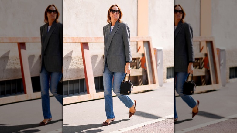 Une femme portant un jean droit et un blazer en tweed