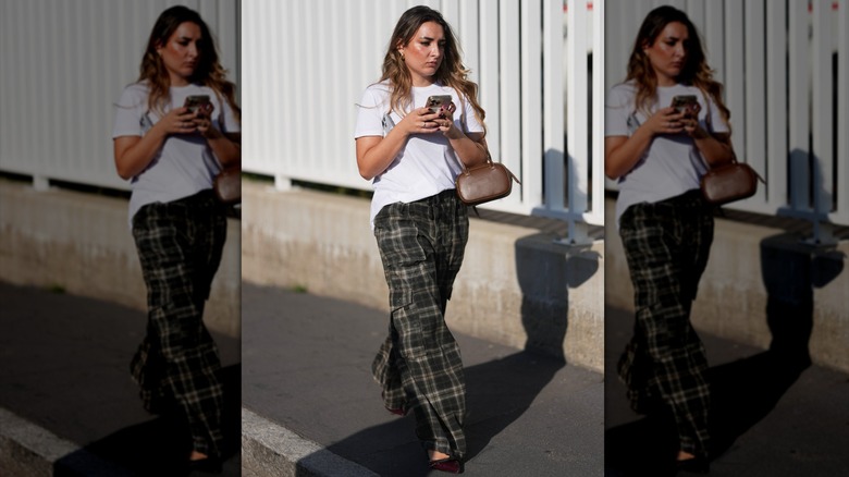 Une femme portant un pantalon à carreaux et un tee-shirt blanc