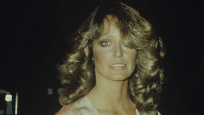 Une photo de Farrah Fawcett la montre avec de gros cheveux bouclés qui couvrent partiellement son visage