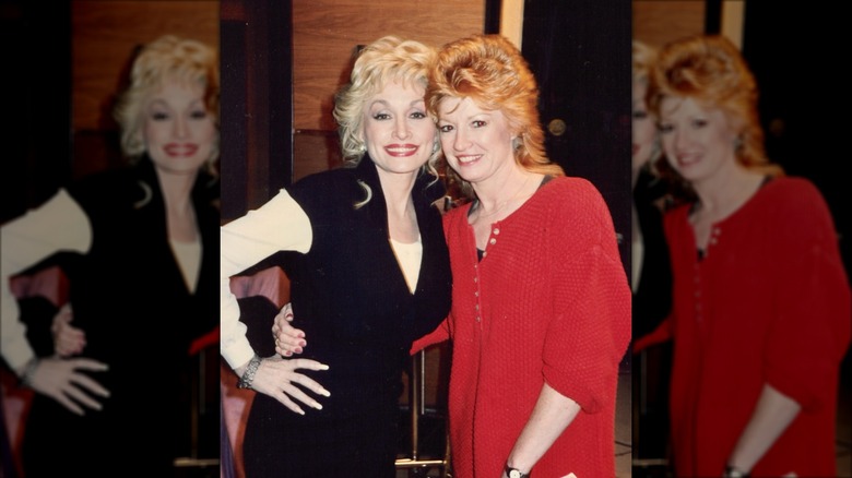 Dolly Parton (à gauche) avec Judy Ogle (à droite) portant des cheveux roux taquinés et une robe rouge boutonnée