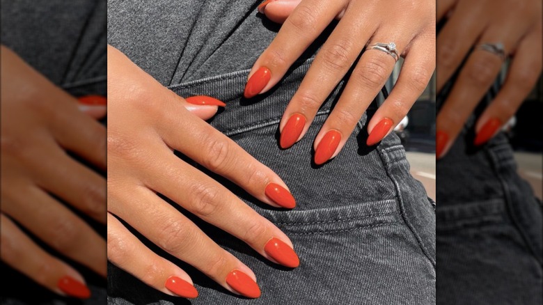 Manucure en forme d'amande avec vernis à ongles orange brûlé