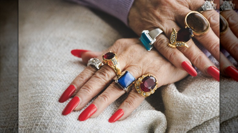 De longs ongles rouges portant de grosses bagues