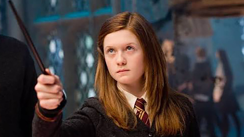 Ginny Weasley de Harry Potter tenant une baguette