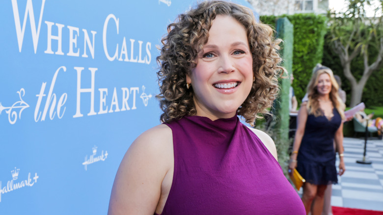 L'acteur Erin Krakow est photographié avec des cheveux bouclés sur le tapis rouge tout en portant une robe violette éclatante