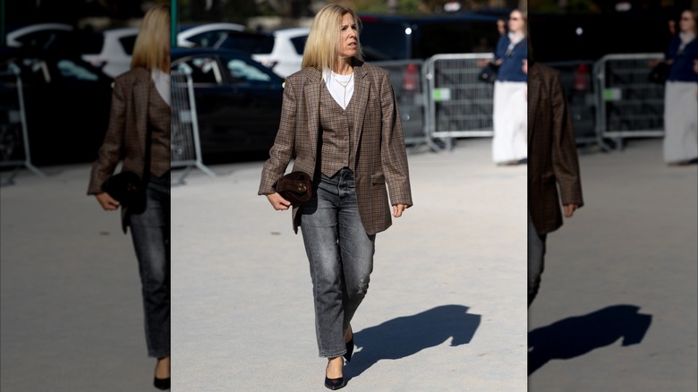 Une femme portant un gilet et un blazer avec un jean et un t-shirt