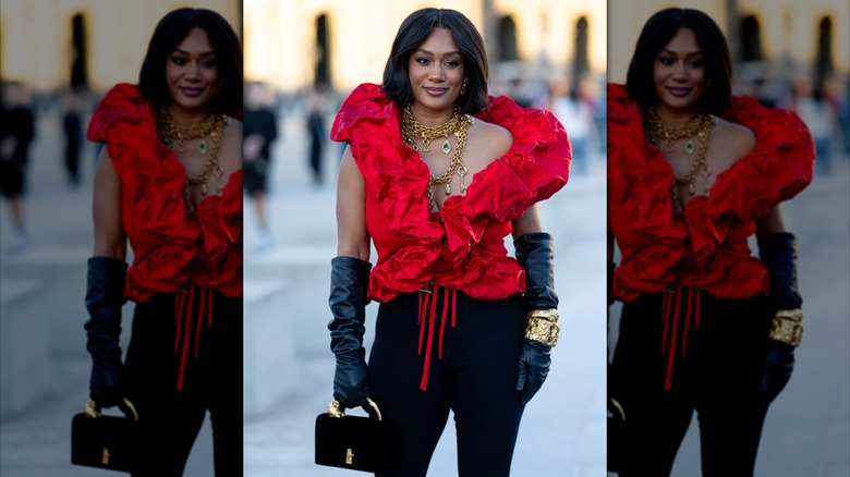 Une femme portant des gants d'opéra noirs et des bijoux en or.