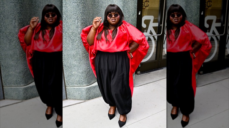 Gabourey Sidibé portant une chemise rouge et un pantalon noir