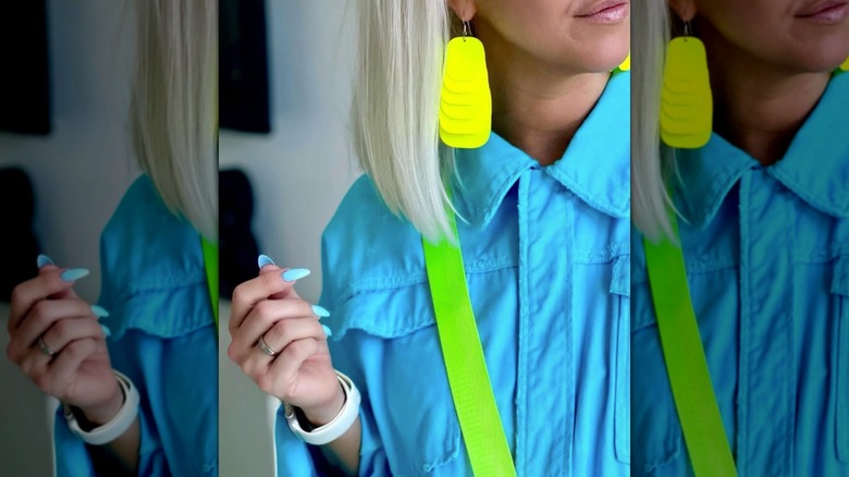 Une femme portant des boucles d'oreilles chandelier jaune fluo