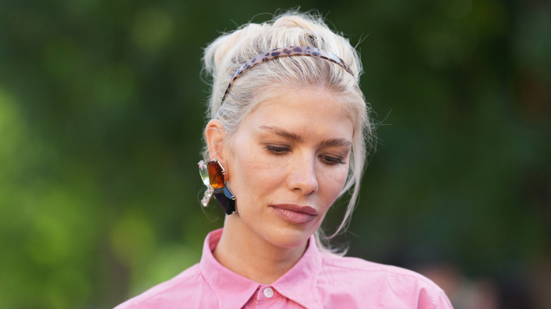 Une femme portant une boucle d'oreille en pierre précieuse.