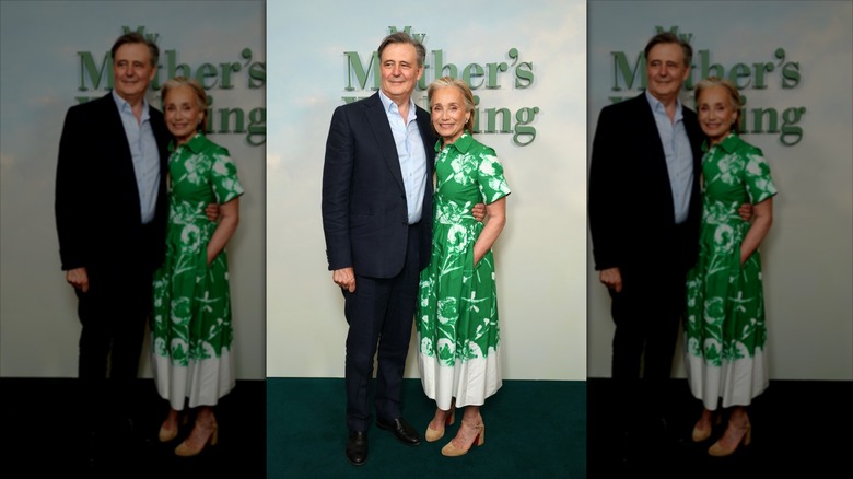 John Micklethwait (à gauche) portant un costume à côté de Kristin Scott Thomas (à droite) portant une robe verte à fleurs