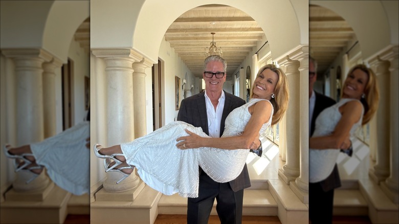 John Donaldson tient Vanna White qui porte une robe de mariée blanche dos nu