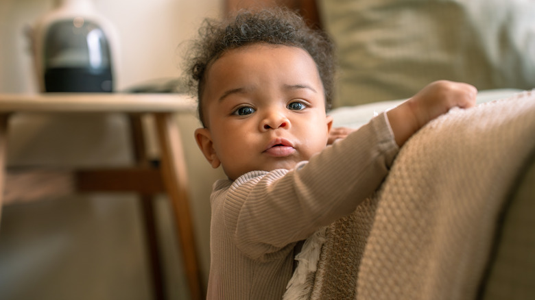 Un bébé qui grimpe sur les meubles
